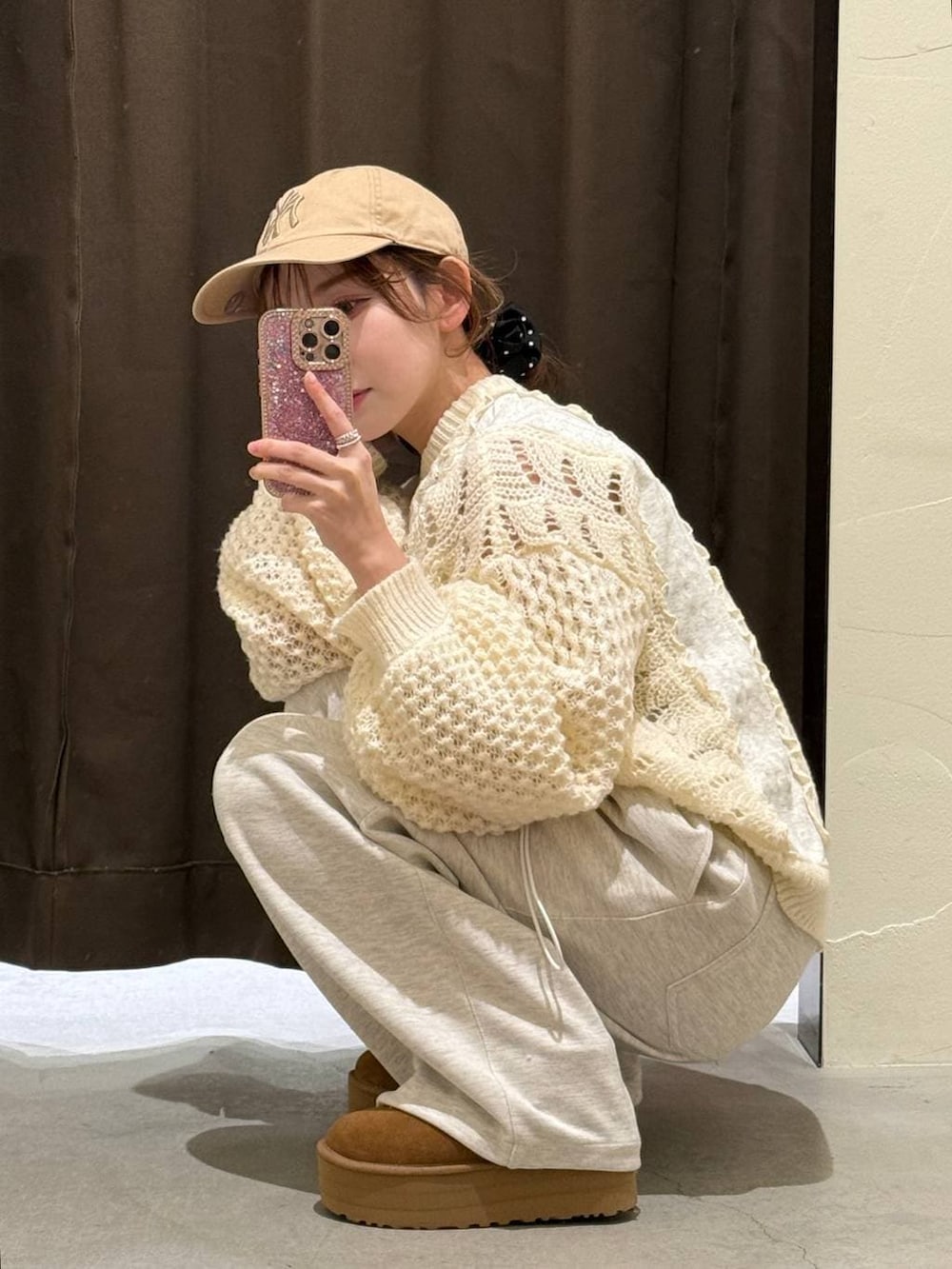 ベージュ系のタンクトップ、グレー系のスウェットパンツ、ブラック系のシュシュを着用したレディースの冬コーディネートの2枚目の写真