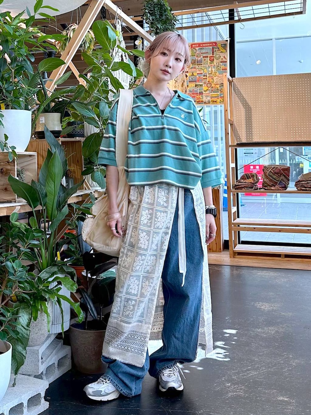 グレー系のスニーカー、グリーン系のポロシャツ、ベージュ系のショルダーバッグを着用したレディースの夏コーディネートの4枚目の写真