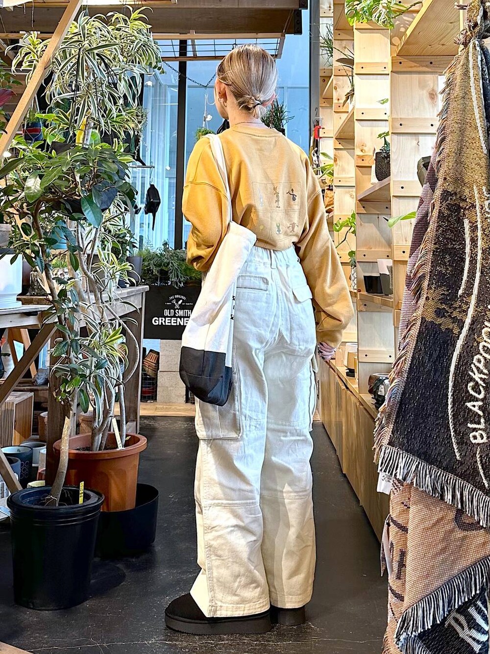 ブラック系のトートバッグ、ブラック系のブーツ、ホワイト系のその他パンツを着用したレディースの冬コーディネートの2枚目の写真