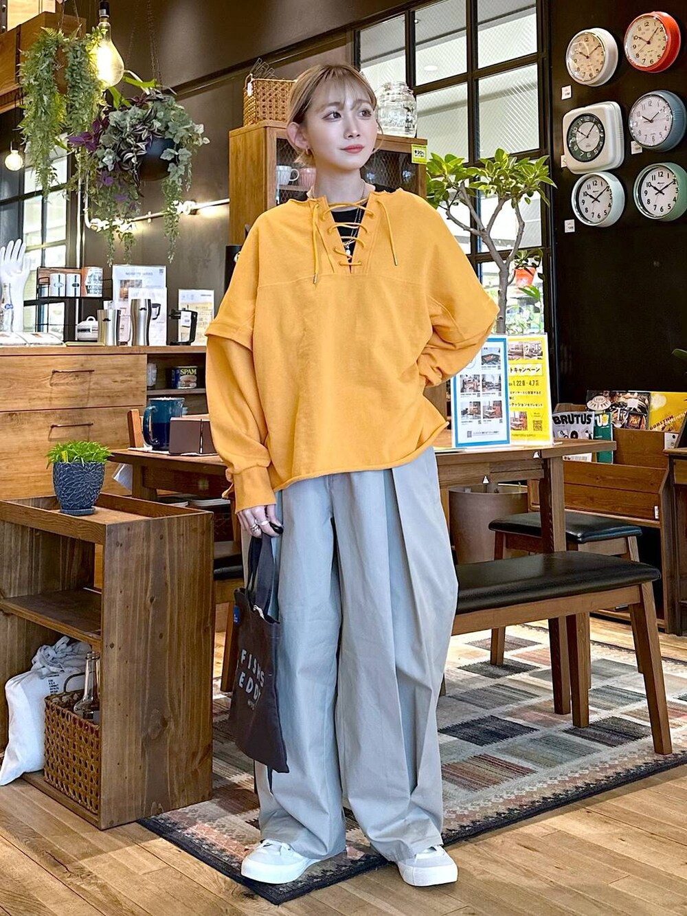ホワイト系のスニーカー、グレー系のチノパンツ、グレー系のトートバッグを着用したレディースの冬コーディネートの3枚目の写真