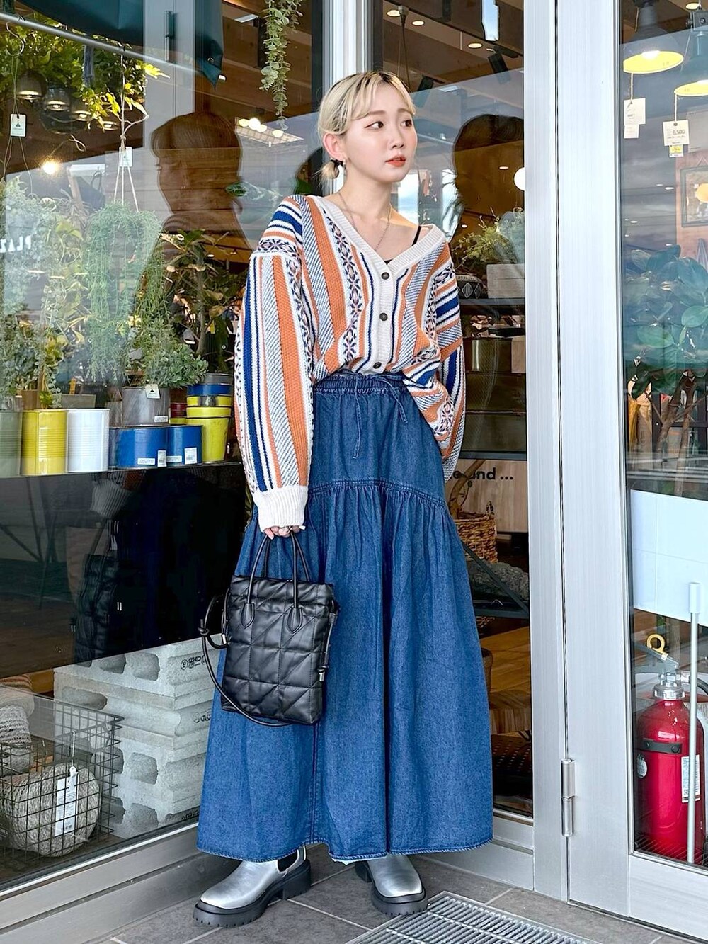 ブラック系のショルダーバッグ、ブラック系のキャミソール、オレンジ系のカーディガン/ボレロを着用したレディースの秋コーディネートの3枚目の写真