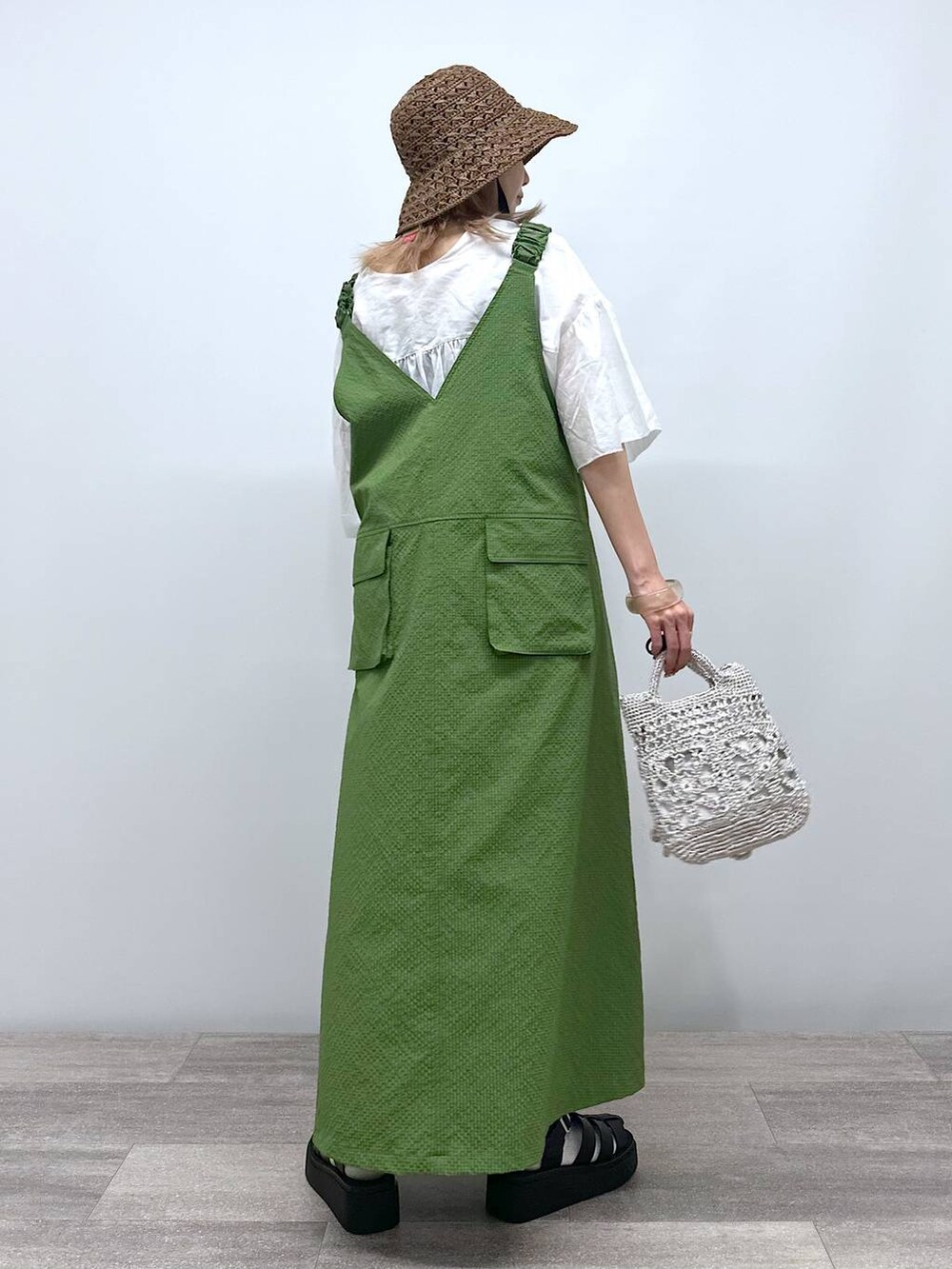 グレー系のショルダーバッグ、ブラック系のサンダル、グリーン系のジャンパースカートを着用したレディースの夏コーディネートの4枚目の写真