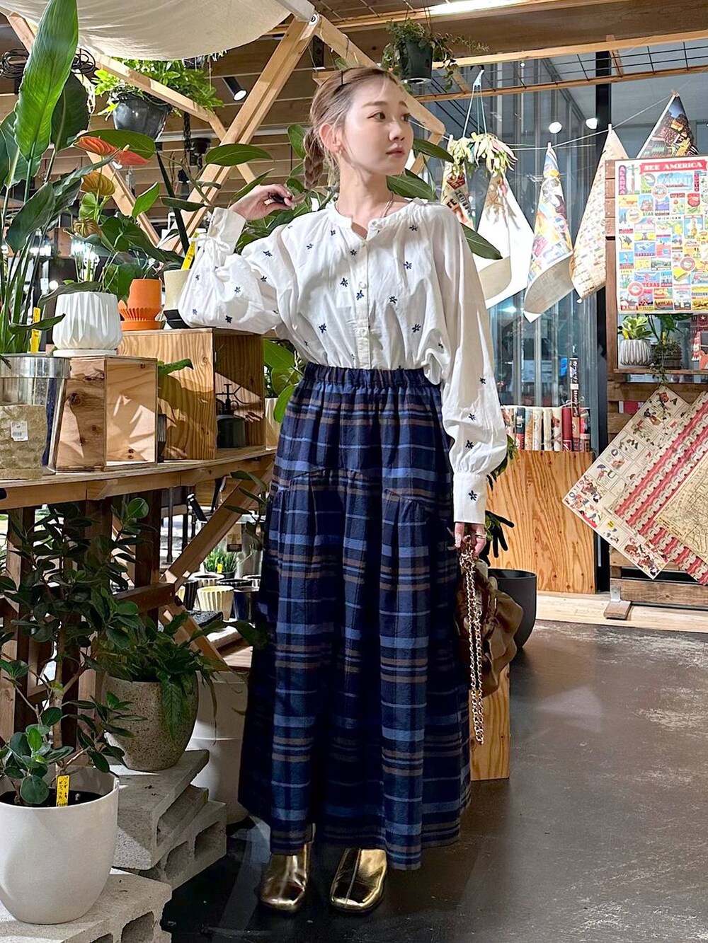 ブルー系のその他パンツ、ゴールド系のブーツ、ブラウン系のショルダーバッグを着用したレディースの夏コーディネートの4枚目の写真