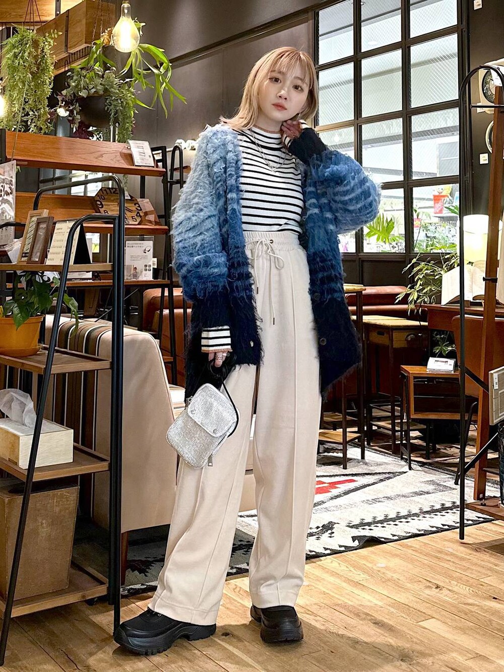 ホワイト系のニット/セーター、ベージュ系のその他パンツ、ブラック系のブーツを着用したレディースの冬コーディネートの2枚目の写真