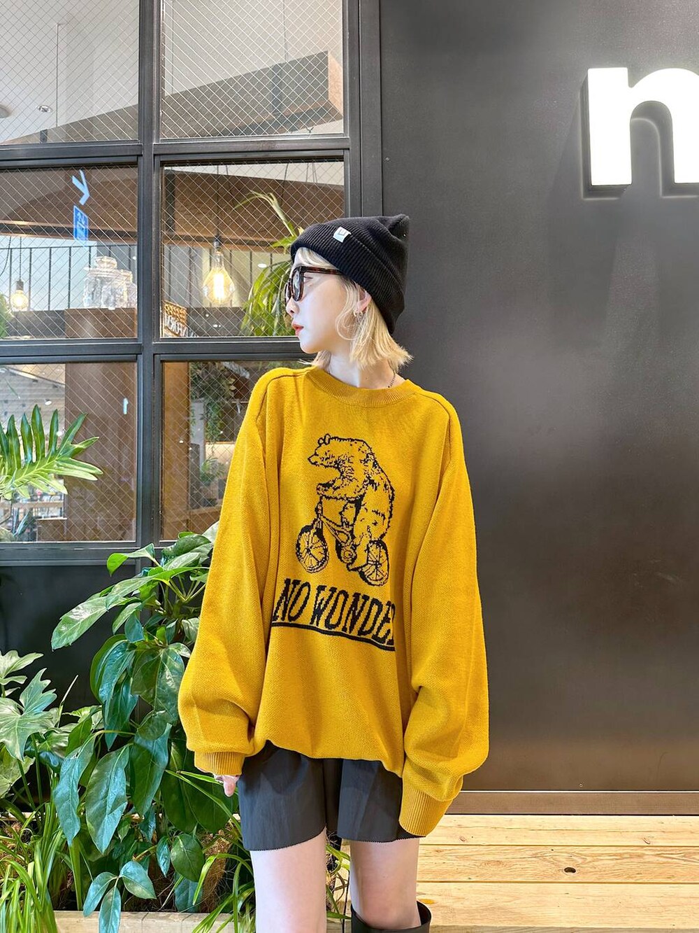 イエロー系のニット/セーター、ブラック系のスカート、ブラック系のニットキャップ/ビーニーを着用したレディースの秋コーディネートの2枚目の写真