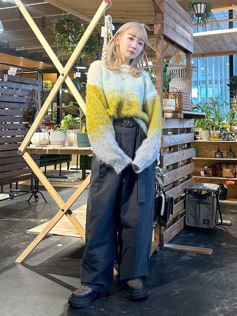 グレー系のその他パンツ、ブラウン系のブーツ、イエロー系のニット/セーターを着用したレディースの冬コーディネートの3枚目の写真