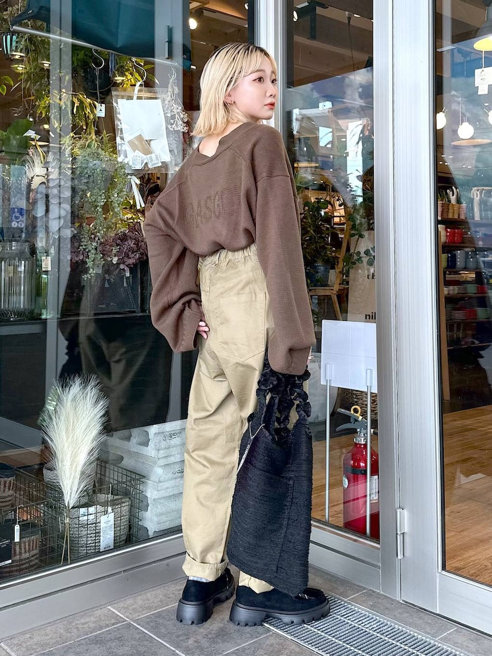 グリーン系のニット/セーター、ブラック系のモカシン/デッキシューズ、イエロー系のその他パンツを着用したレディースの秋コーディネートの2枚目の写真