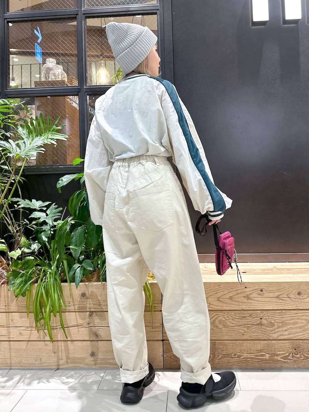 パープル系のショルダーバッグ、ベージュ系のその他パンツ、ブラック系のスニーカーを着用したレディースの秋コーディネートの3枚目の写真