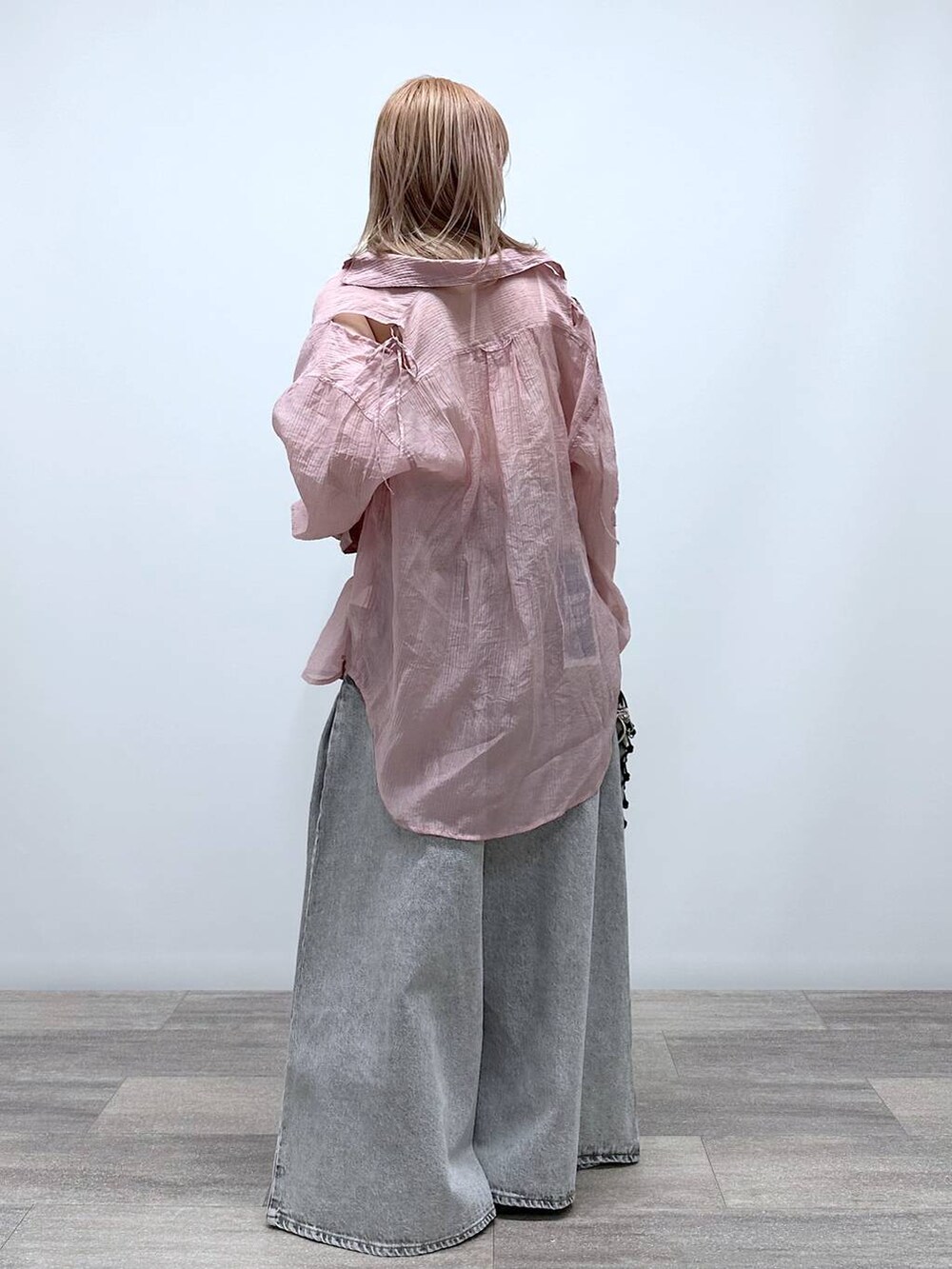 ブラック系のショルダーバッグ、ブラック系のサンダル、グレー系のデニムパンツを着用したレディースの春コーディネートの2枚目の写真