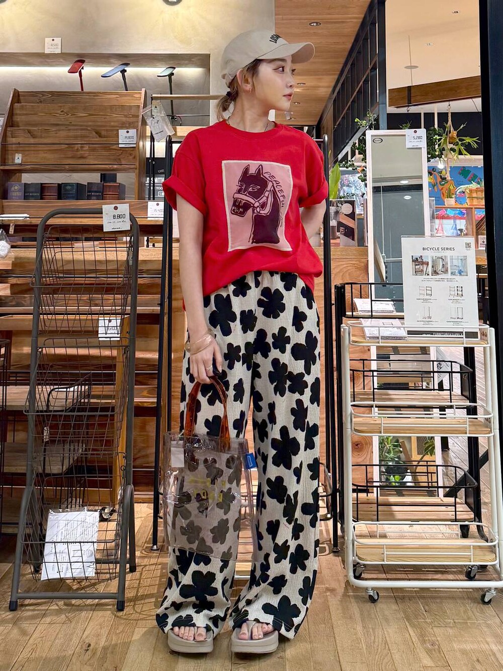 ホワイト系のその他パンツ、グレー系のトートバッグ、レッド系のTシャツ/カットソーを着用したレディースの春コーディネートの3枚目の写真