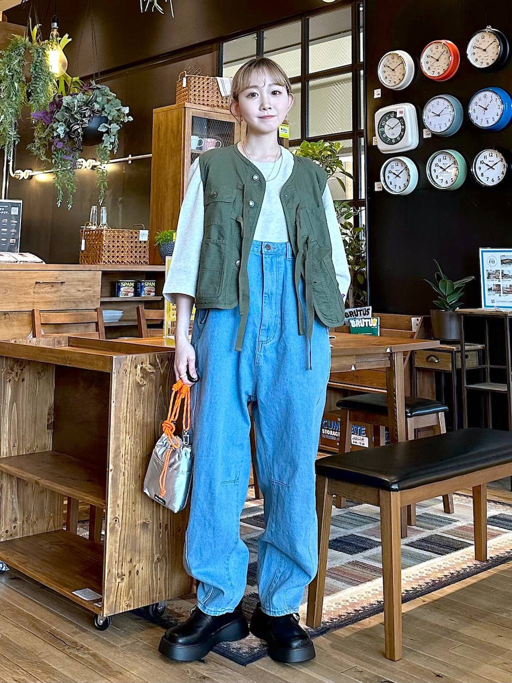 ブルー系のその他パンツ、グリーン系のベスト、グレー系のショルダーバッグを着用したレディースの冬コーディネートの2枚目の写真
