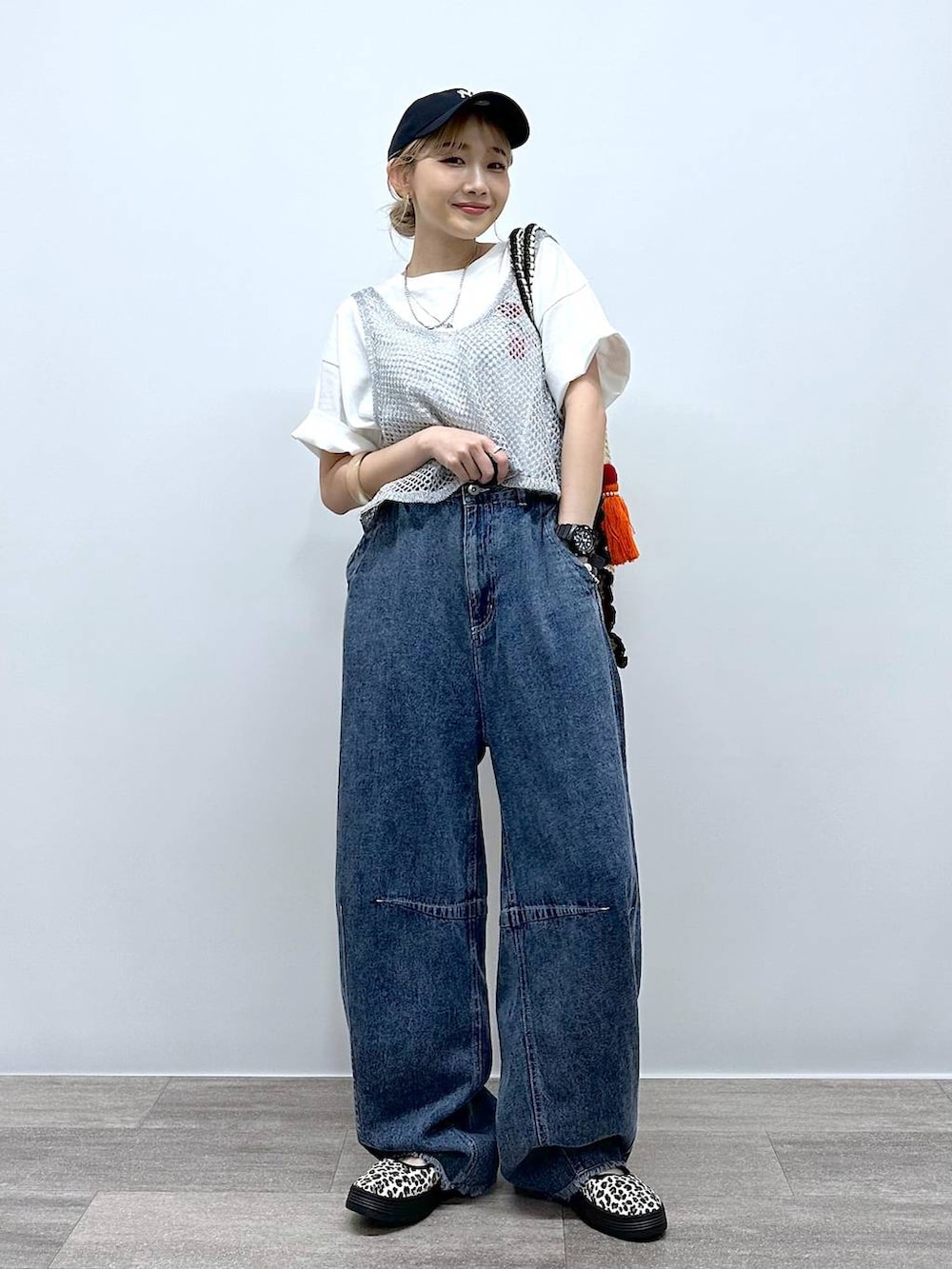 ベージュ系のトートバッグ、その他のスニーカー、ブルー系のデニムパンツを着用したレディースの夏コーディネートの4枚目の写真