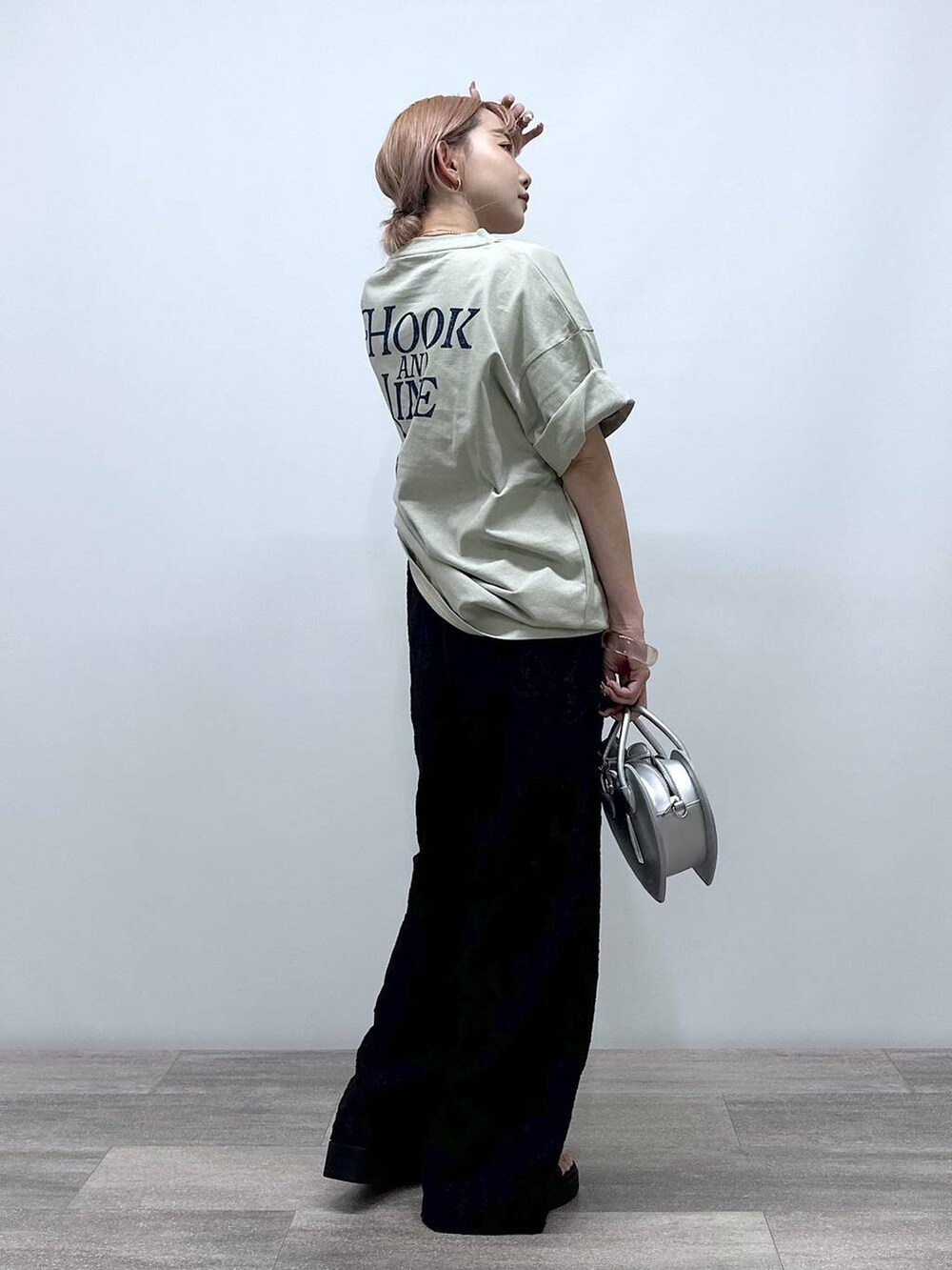 シルバー系のショルダーバッグ、ベージュ系のTシャツ/カットソー、ブラック系のその他パンツを着用したレディースの春コーディネートの2枚目の写真