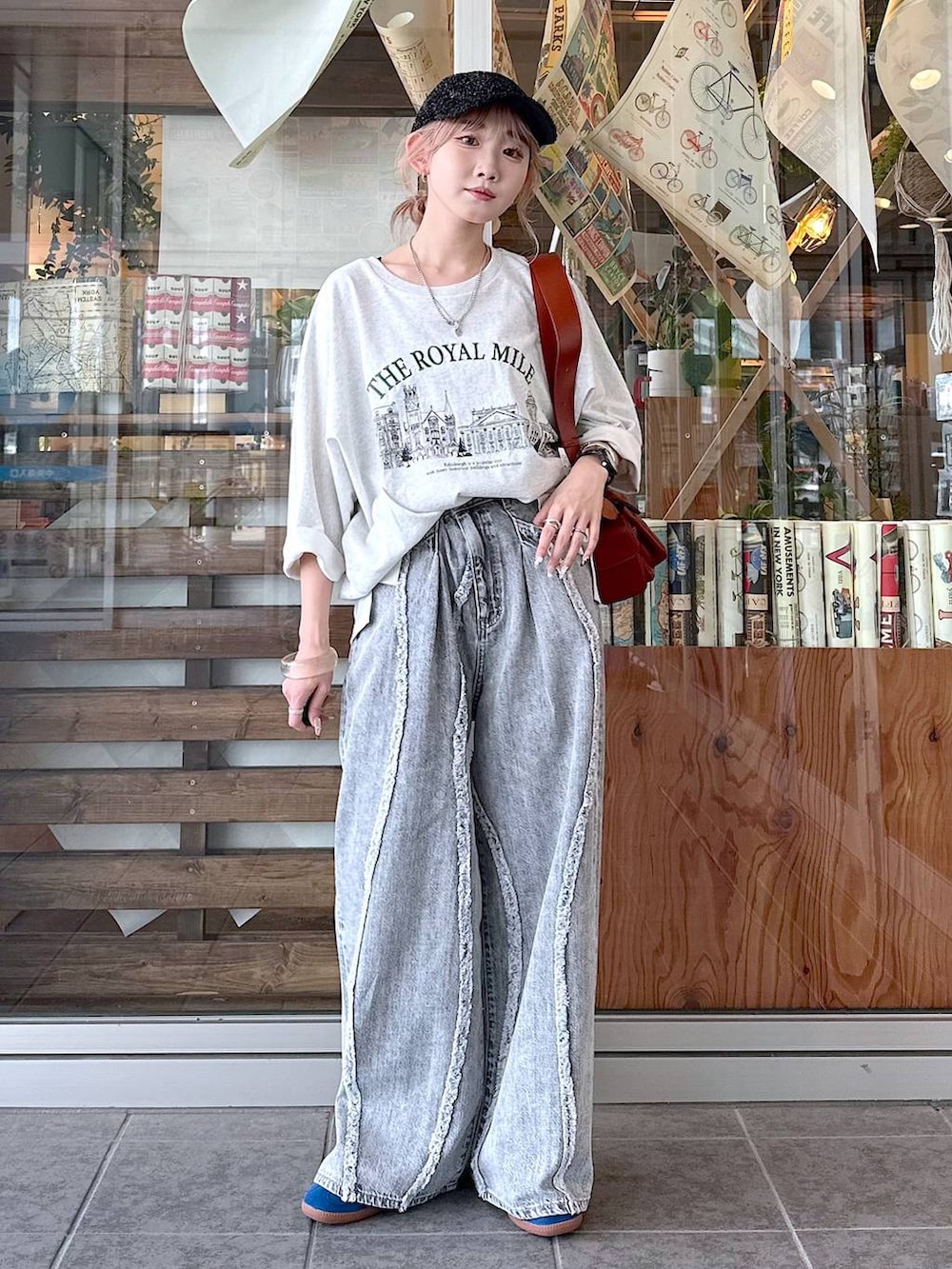 ベージュ系のTシャツ/カットソー、グレー系のデニムパンツ、ブラウン系のショルダーバッグを着用したレディースの夏コーディネートの2枚目の写真
