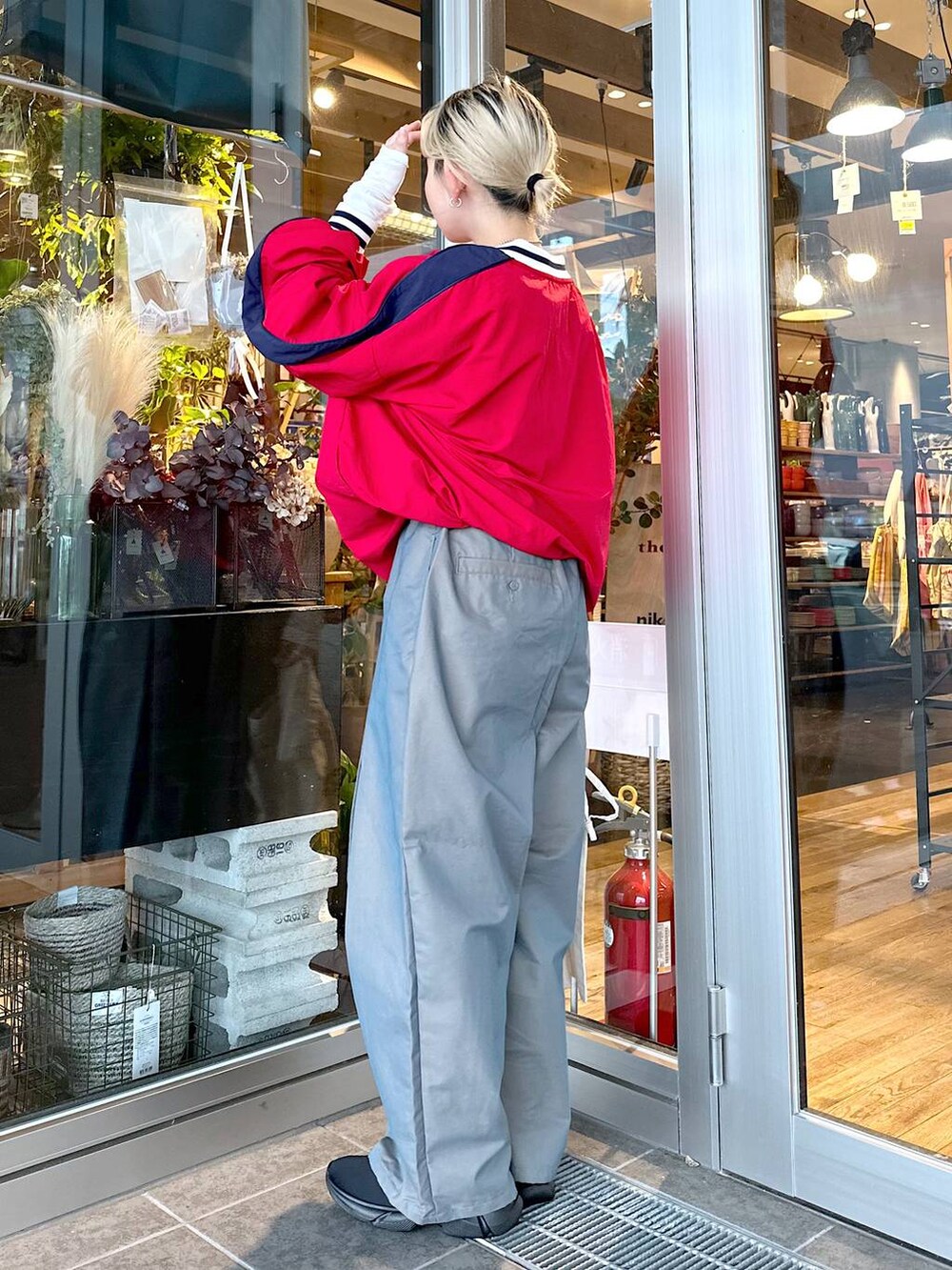 ベージュ系のトートバッグ、グリーン系のチノパンツ、ブラック系のスニーカーを着用したレディースの秋コーディネートの2枚目の写真