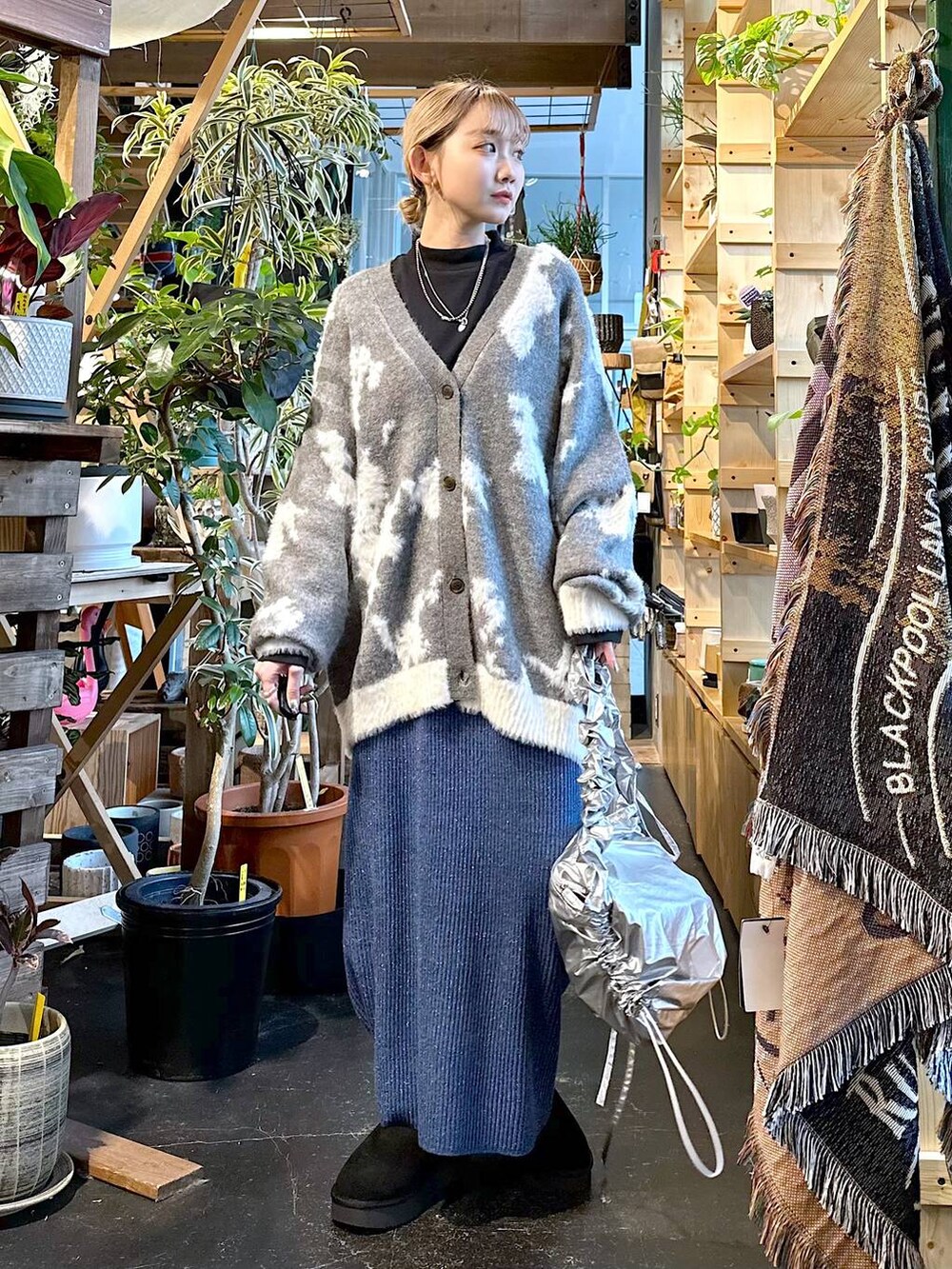 ブラック系のブーツ、ブラック系のTシャツ/カットソー、グレー系のショルダーバッグを着用したレディースの冬コーディネートの4枚目の写真