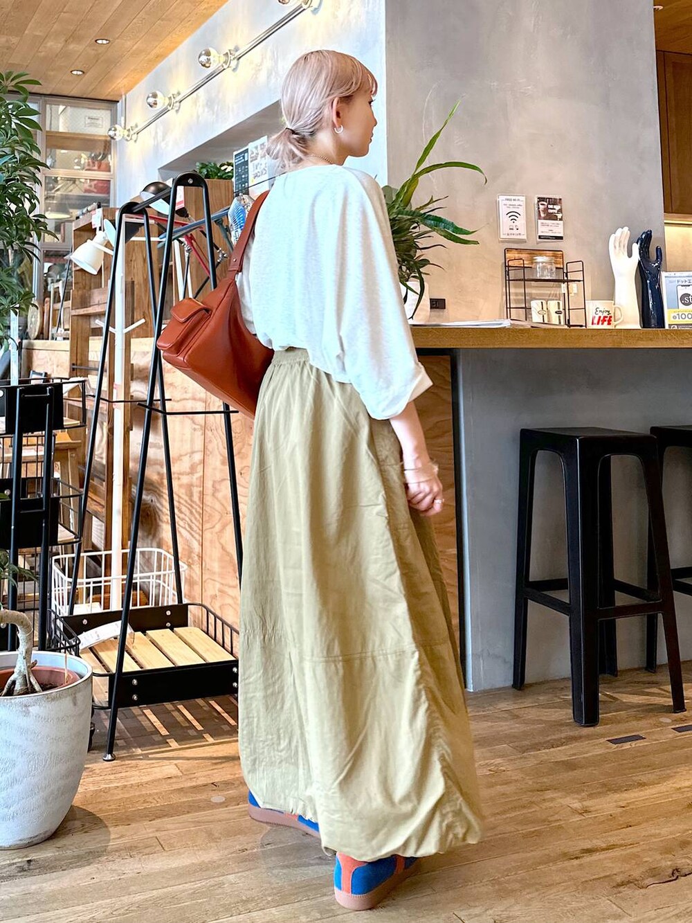 ベージュ系のTシャツ/カットソー、ブラウン系のショルダーバッグ、ブルー系のスニーカーを着用したレディースの夏コーディネートの5枚目の写真