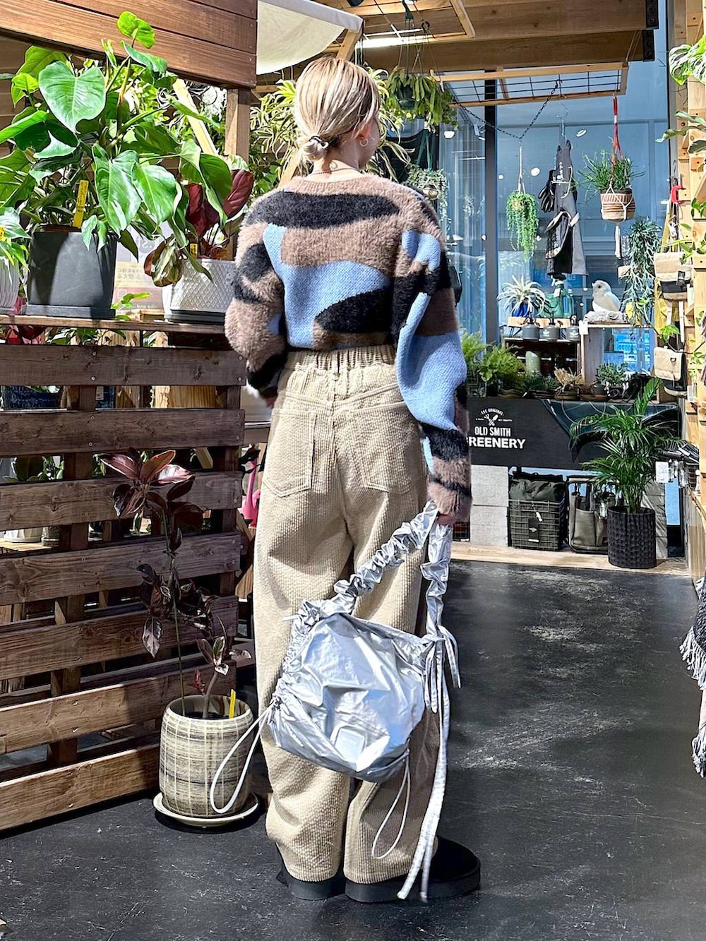 ブラック系のブーツ、グレー系のショルダーバッグ、イエロー系のその他パンツを着用したレディースの冬コーディネートの2枚目の写真