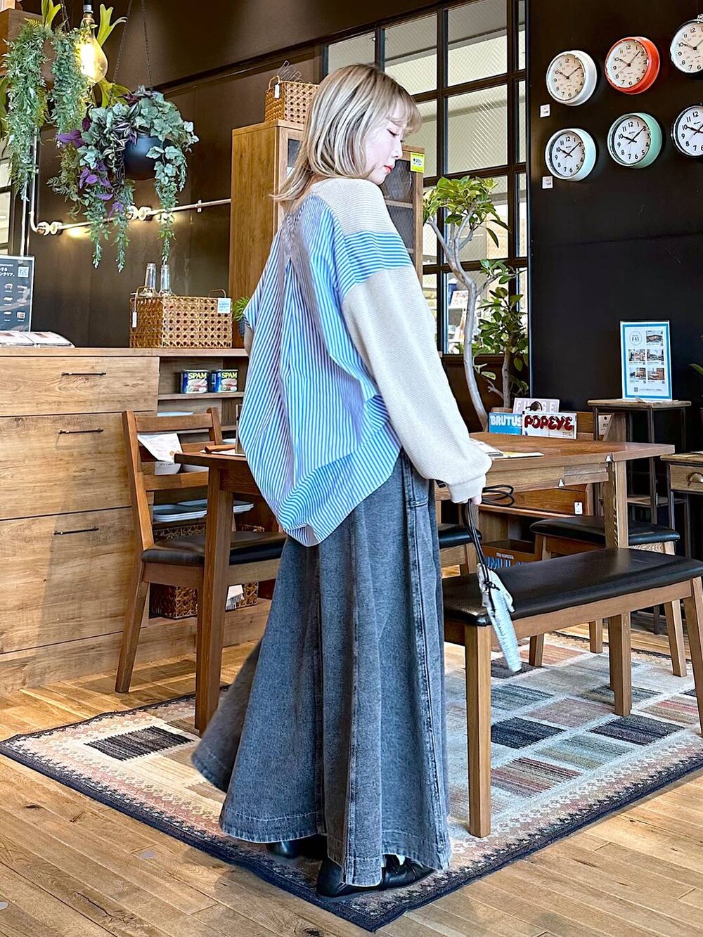 イエロー系のTシャツ/カットソー、グレー系のスカート、ブラック系のパンプスを着用したレディースの春コーディネートの2枚目の写真