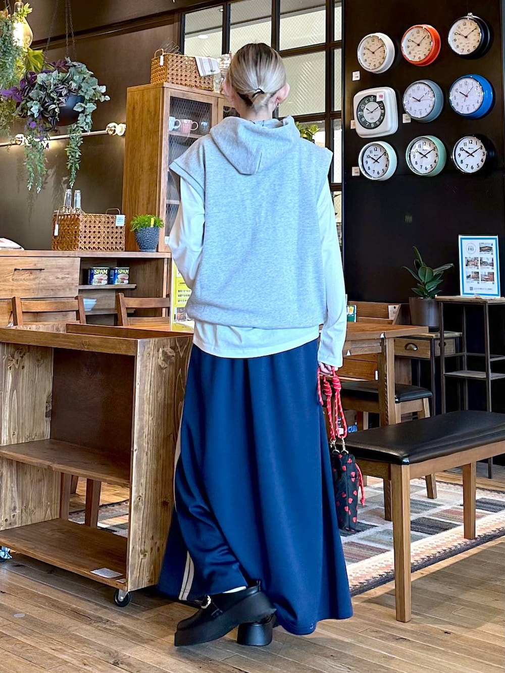 ブラック系のショルダーバッグ、ホワイト系のTシャツ/カットソー、ブルー系のスカートを着用したレディースの冬コーディネートの3枚目の写真