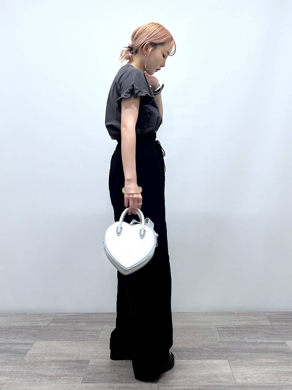 シルバー系のショルダーバッグ、グレー系のTシャツ/カットソー、ブラック系のその他パンツを着用したレディースの夏コーディネートの3枚目の写真