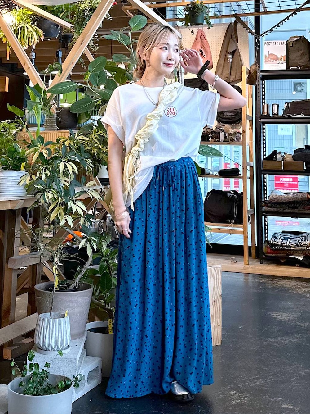 ベージュ系のショルダーバッグ、ブルー系のその他パンツ、シルバー系のスニーカーを着用したレディースの夏コーディネートの2枚目の写真