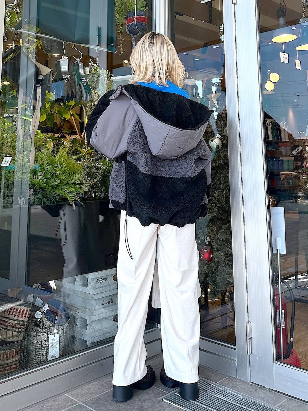 ブラック系のトートバッグ、その他のブーツ、ベージュ系のその他パンツを着用したレディースの秋コーディネートの2枚目の写真