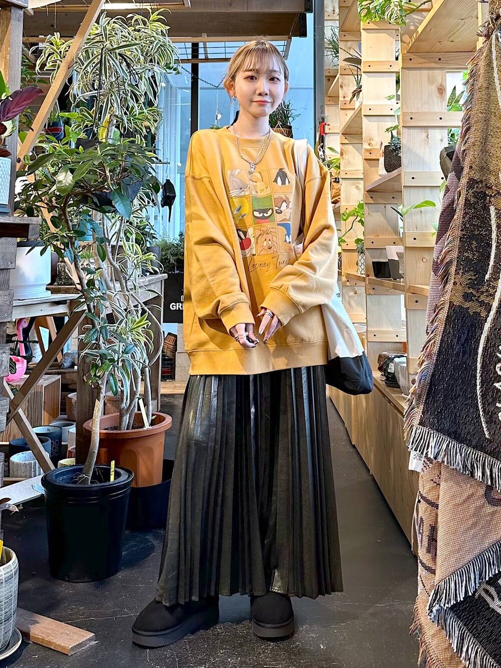 ブラック系のトートバッグ、ブラック系のブーツ、イエロー系のスウェットを着用したレディースの冬コーディネートの2枚目の写真