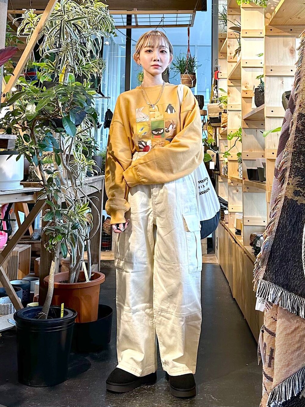 ブラック系のトートバッグ、ブラック系のブーツ、ホワイト系のその他パンツを着用したレディースの冬コーディネートの5枚目の写真