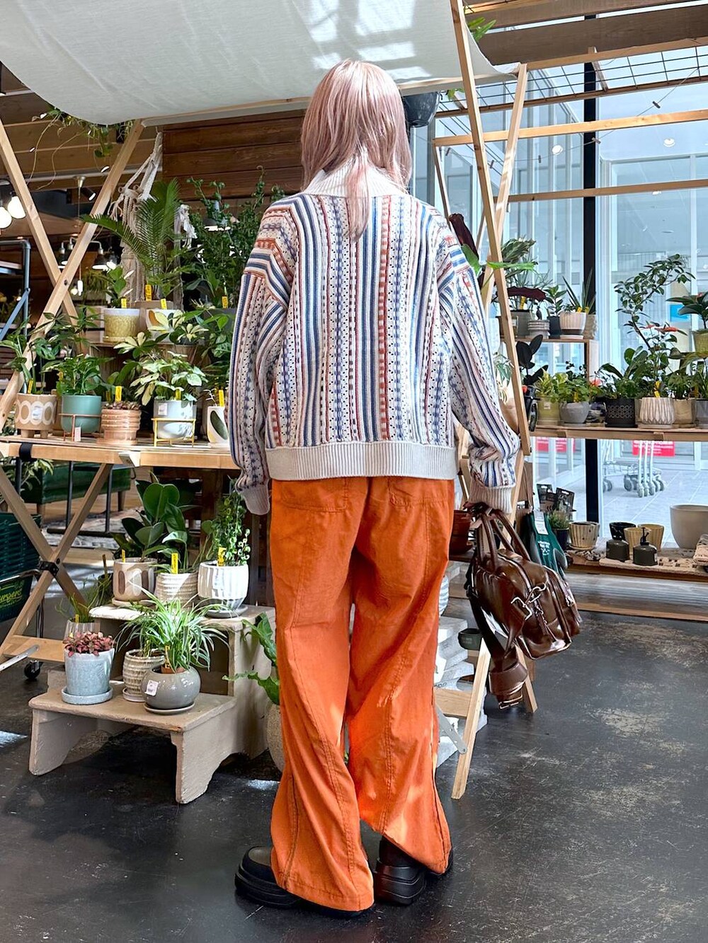 オレンジ系のその他パンツ、ベージュ系のカーディガン/ボレロ、ブラック系のキャミソールを着用したレディースの秋コーディネートの2枚目の写真