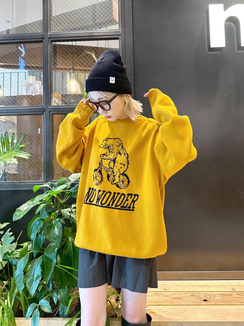 イエロー系のニット/セーター、ブラック系のスカート、ブラック系のニットキャップ/ビーニーを着用したレディースの秋コーディネートの5枚目の写真