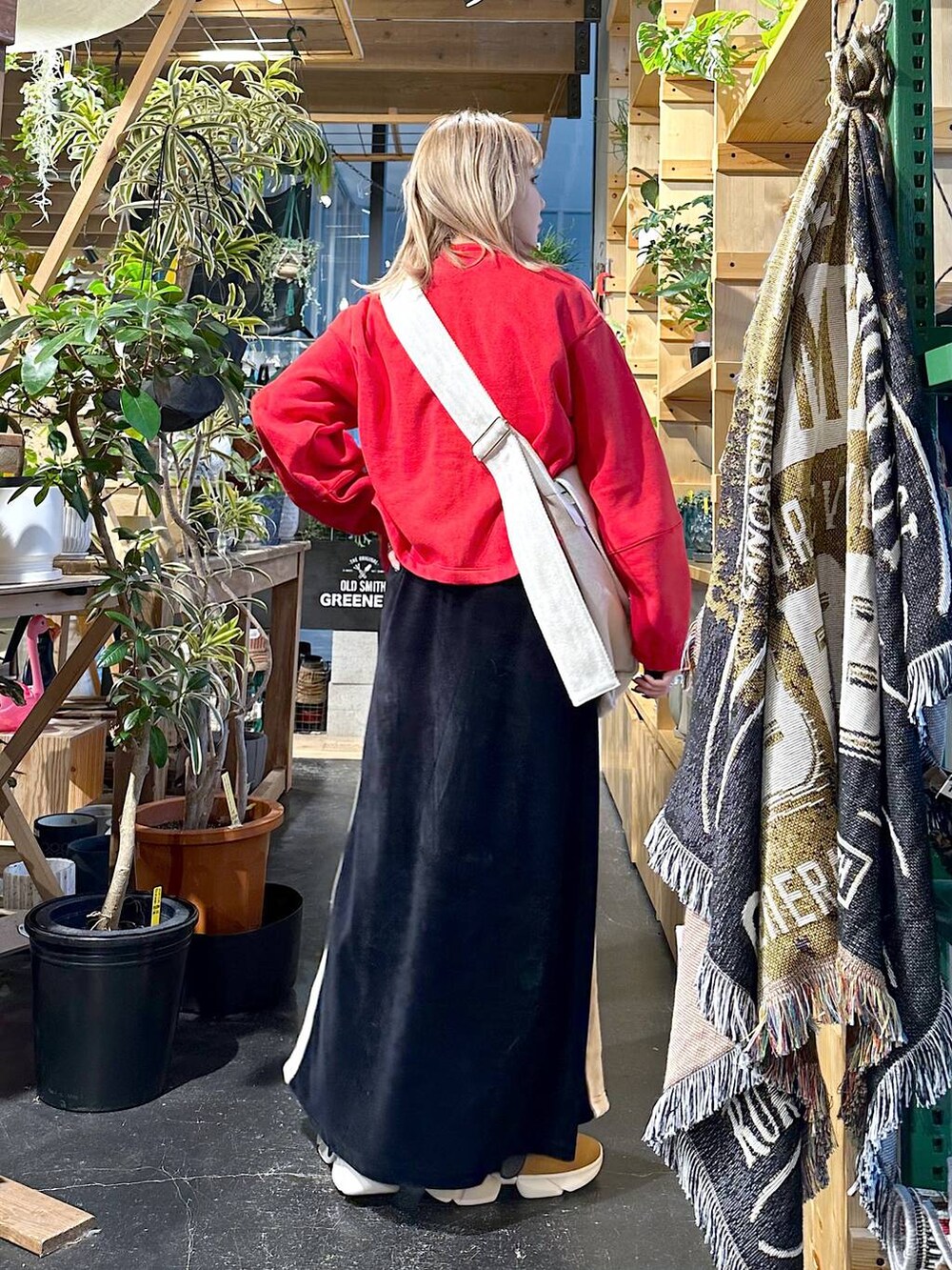 イエロー系のスニーカー、ホワイト系のTシャツ/カットソー、レッド系のTシャツ/カットソーを着用したレディースの冬コーディネートの2枚目の写真