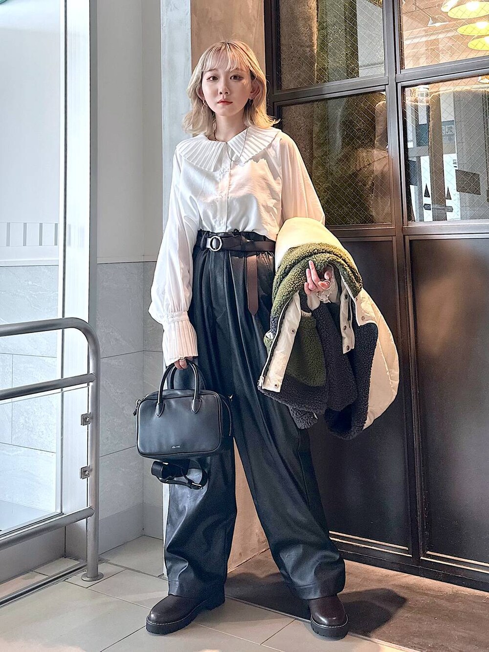 ブラック系のその他パンツ、ブラウン系のその他シューズ、ブラック系のショルダーバッグを着用したレディースの秋コーディネートの2枚目の写真