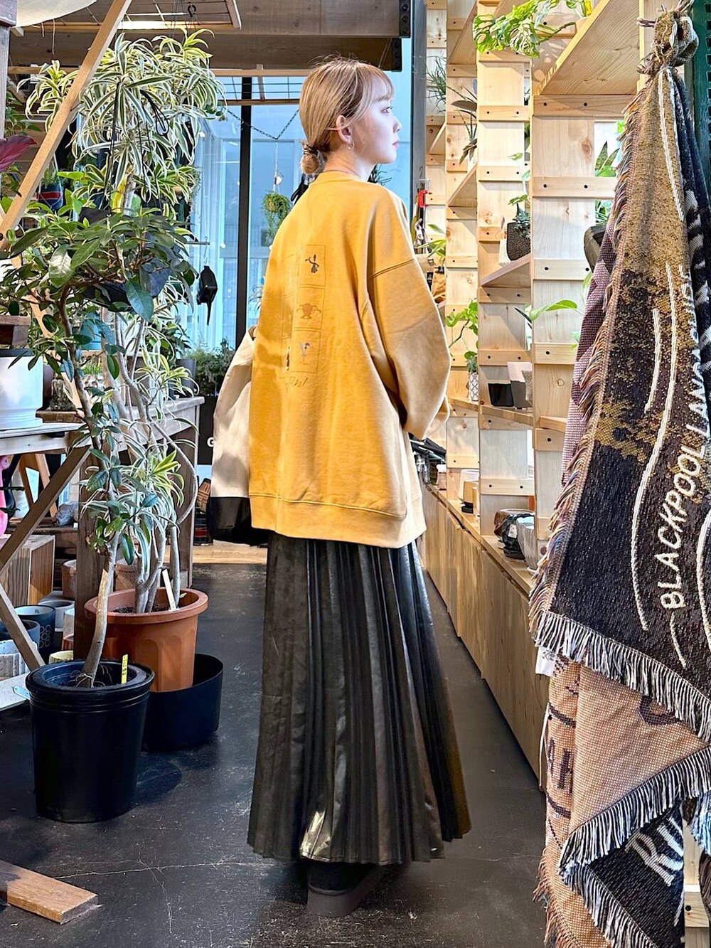 ブラック系のトートバッグ、ブラック系のブーツ、イエロー系のスウェットを着用したレディースの冬コーディネートの6枚目の写真