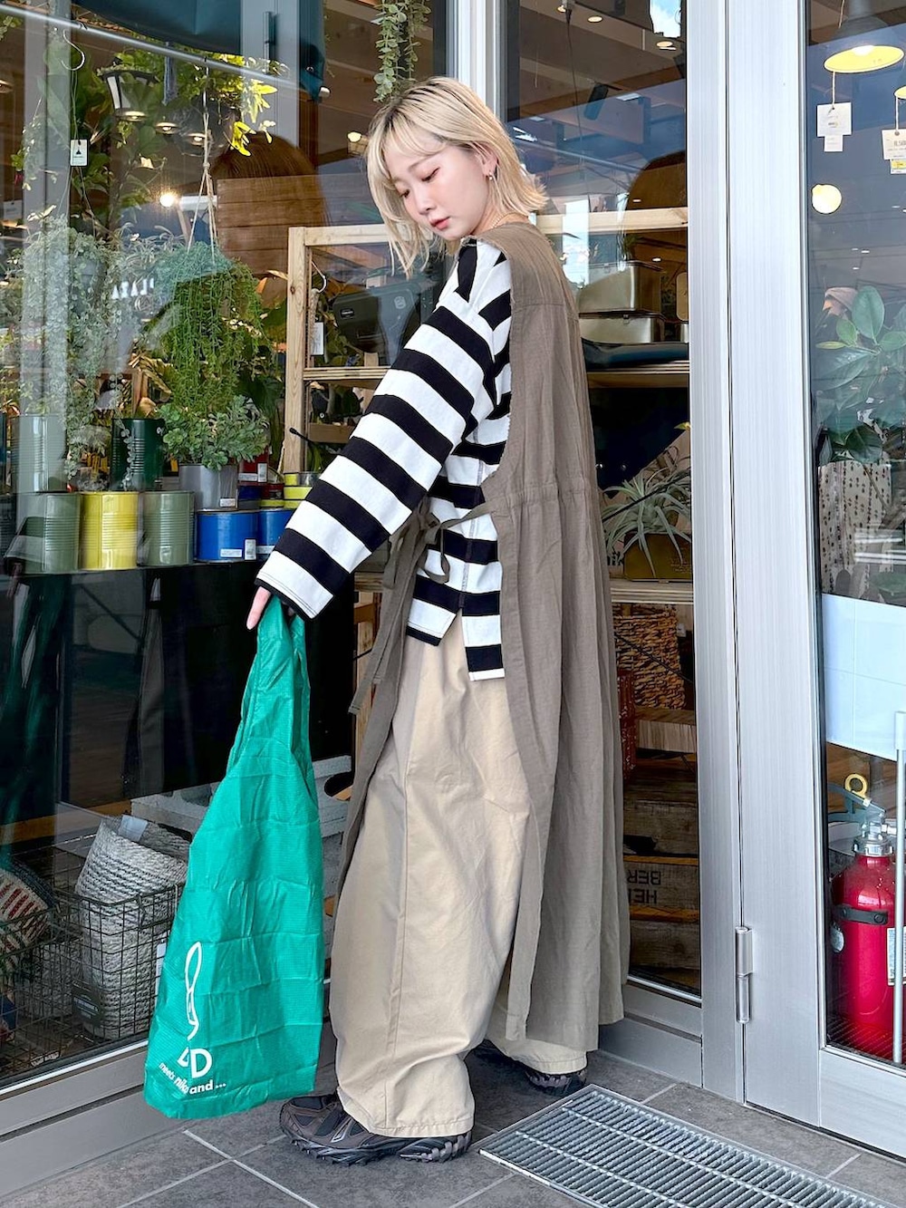 ブラック系のTシャツ/カットソー、ブラウン系のスニーカー、イエロー系のチノパンツを着用したレディースの夏コーディネートの2枚目の写真