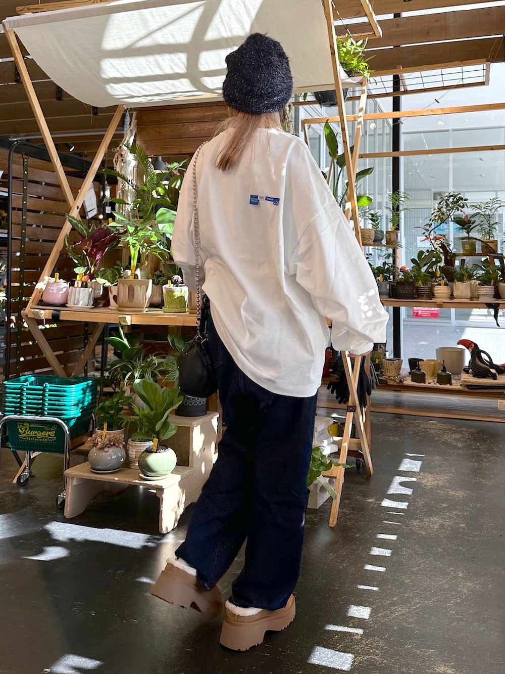 イエロー系のその他シューズ、ブルー系のデニムパンツ、ブラック系のショルダーバッグを着用したレディースの秋コーディネートの2枚目の写真