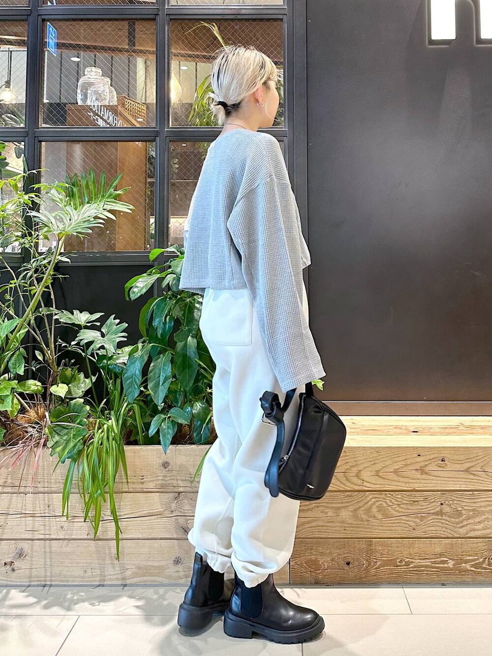 ブラック系のショルダーバッグ、その他のスウェットパンツ、ブラック系のブーツを着用したレディースの秋コーディネートの2枚目の写真