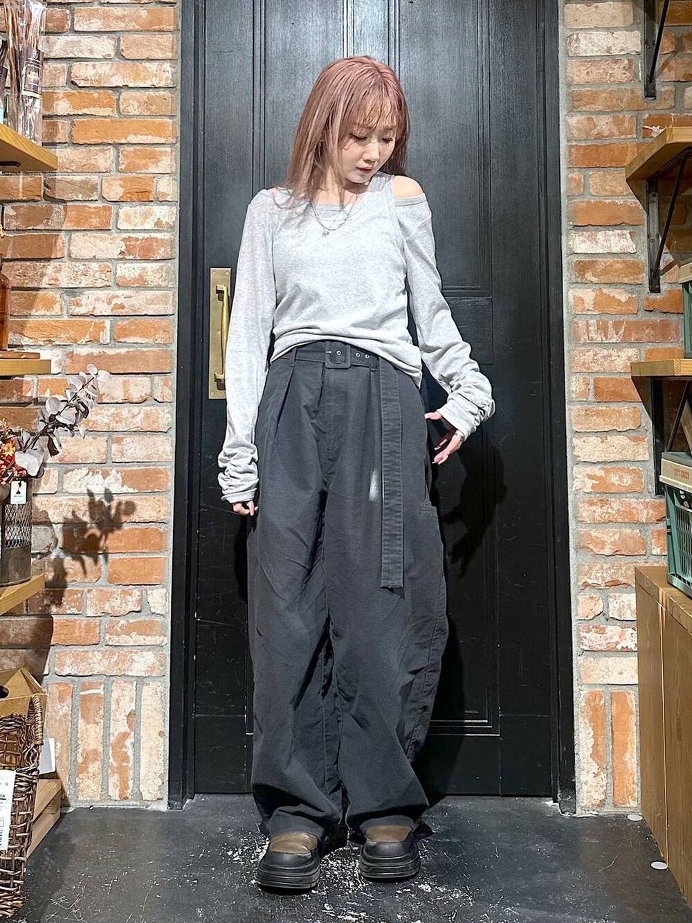 グレー系のその他パンツ、ブラウン系のブーツ、イエロー系のピアス(両耳用)を着用したレディースの冬コーディネートの6枚目の写真