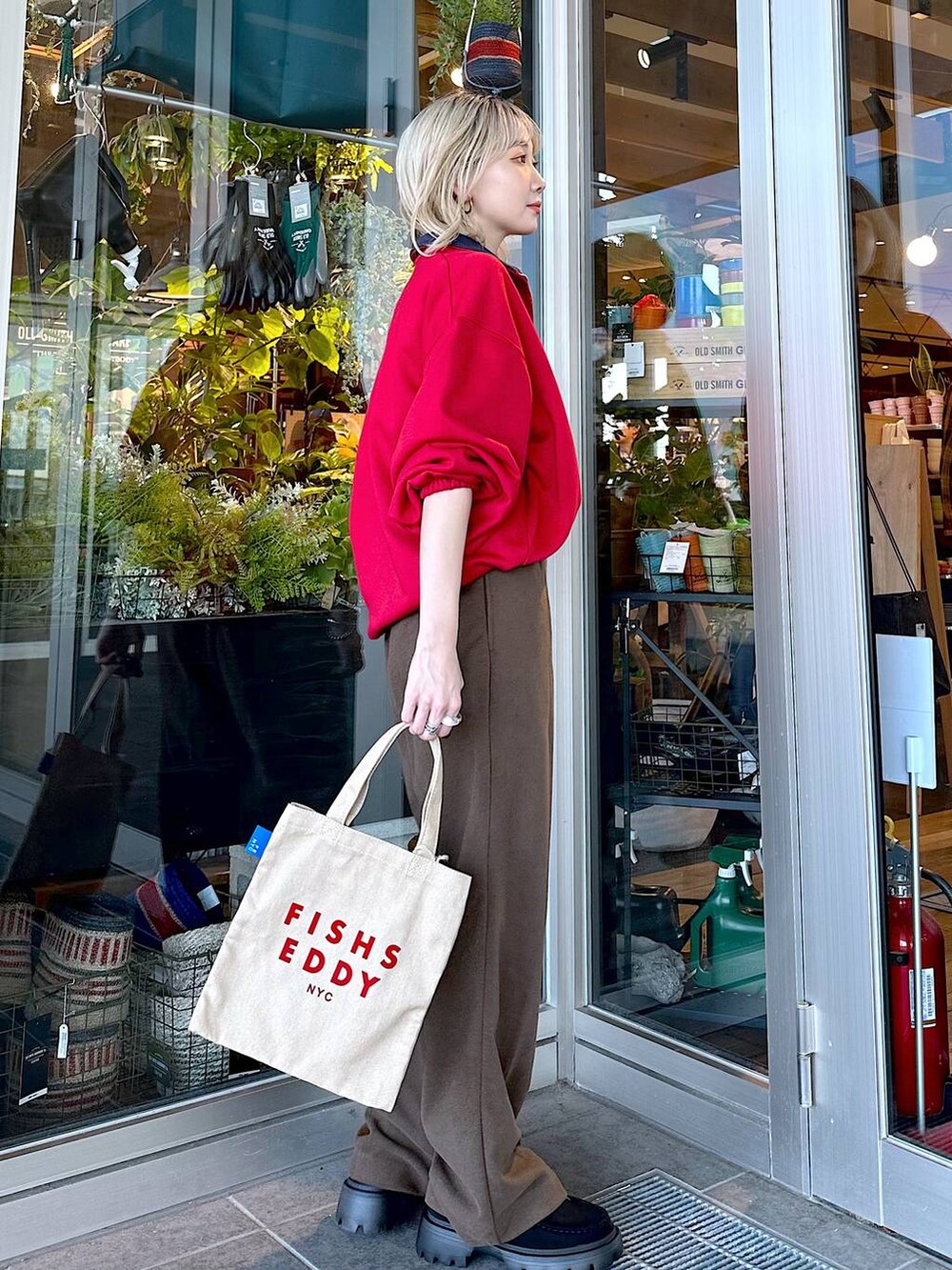 イエロー系のモカシン/デッキシューズ、レッド系のスウェット、ブラウン系のその他パンツを着用したレディースの秋コーディネートの4枚目の写真