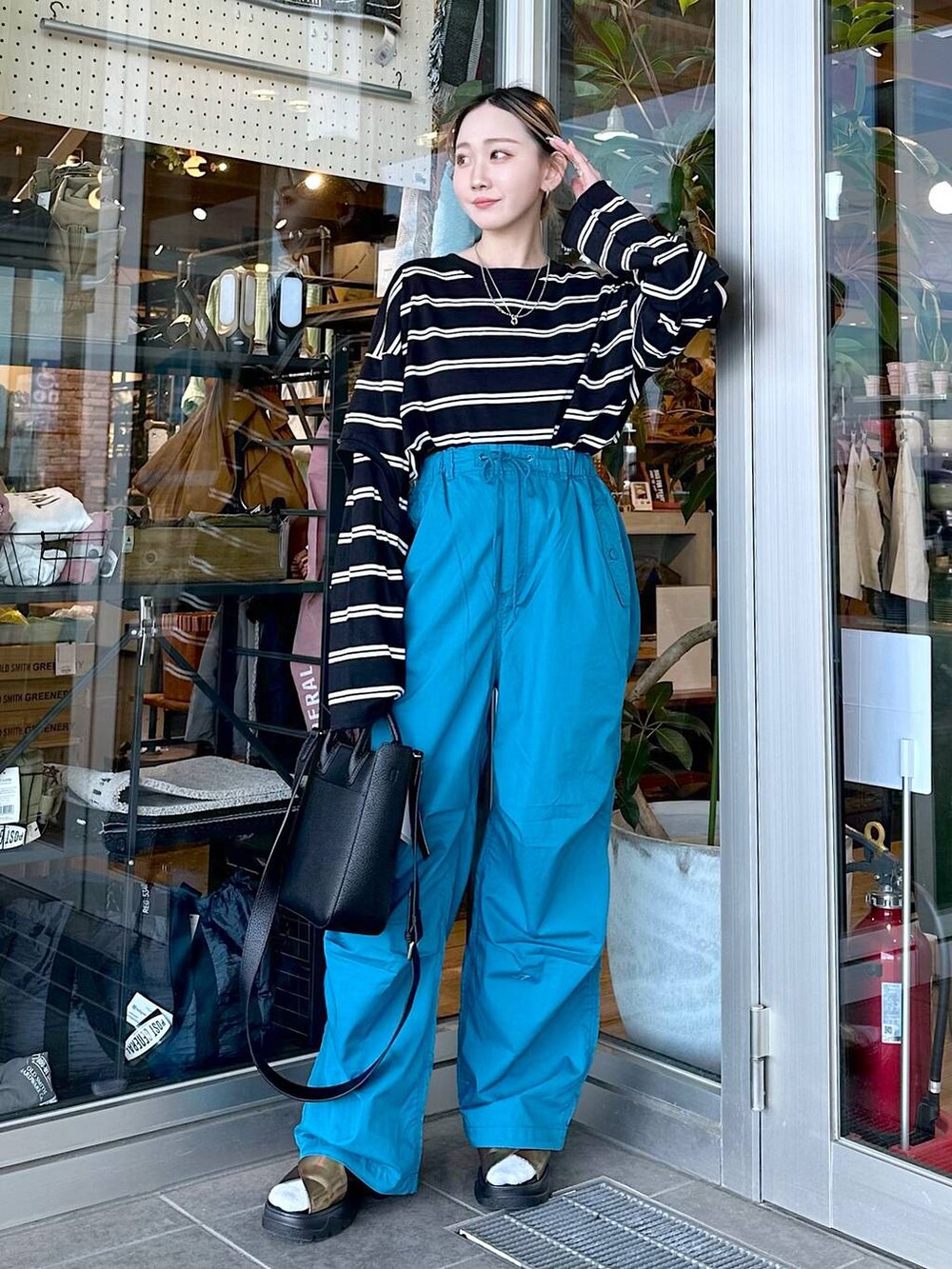 その他のサンダル、ブラック系のトートバッグ、ブラック系のTシャツ/カットソーを着用したレディースの春コーディネートの4枚目の写真