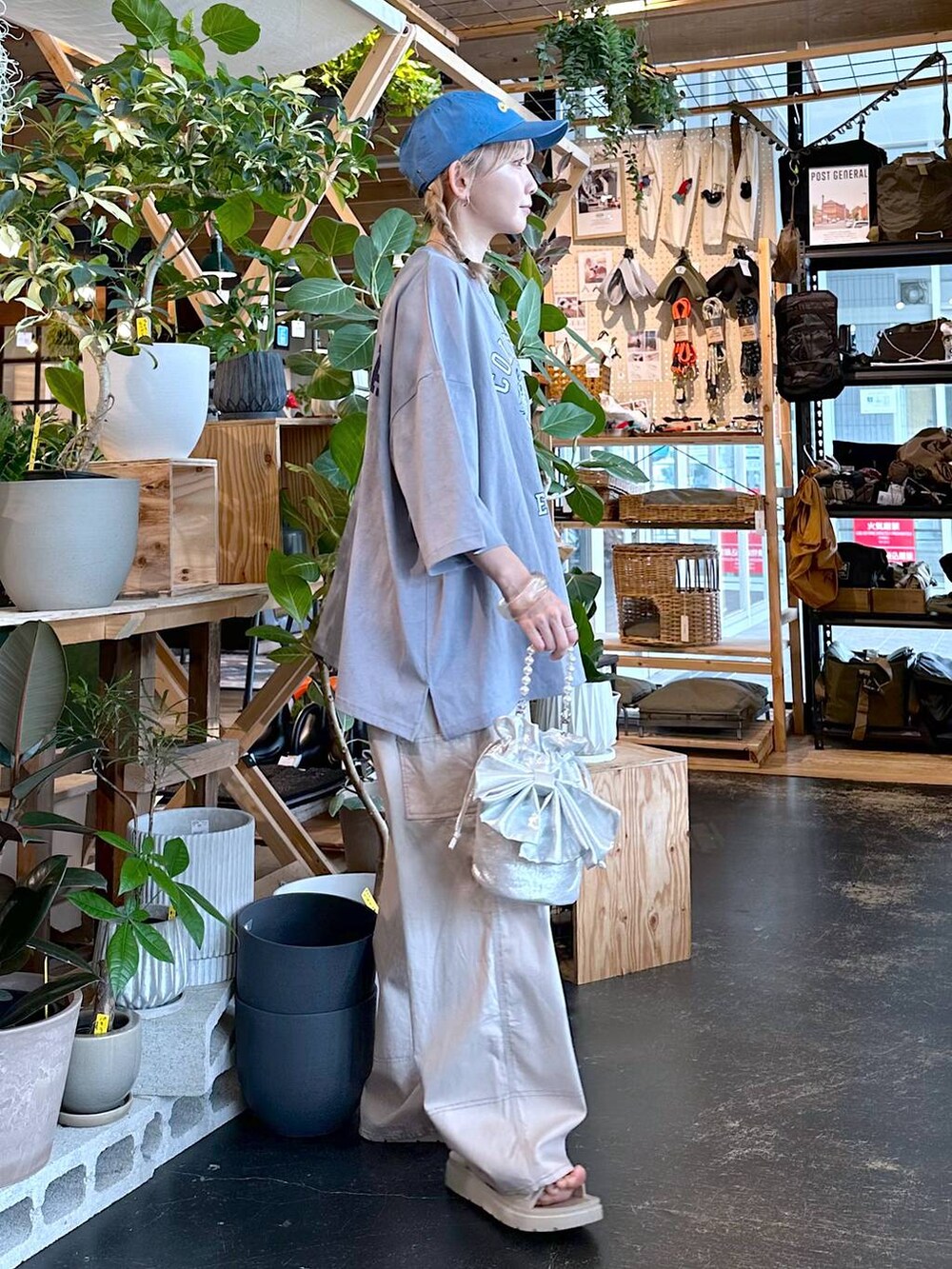 ベージュ系のその他パンツ、グレー系のショルダーバッグ、ブルー系のキャップを着用したレディースの夏コーディネートの3枚目の写真