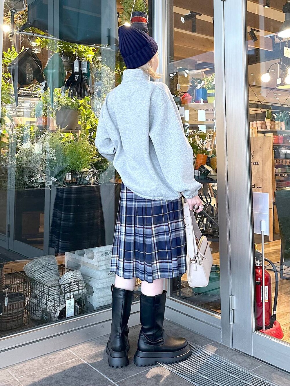 ブラック系のブーツ、ブルー系のスカート、グレー系のスウェットを着用したレディースの秋コーディネートの2枚目の写真