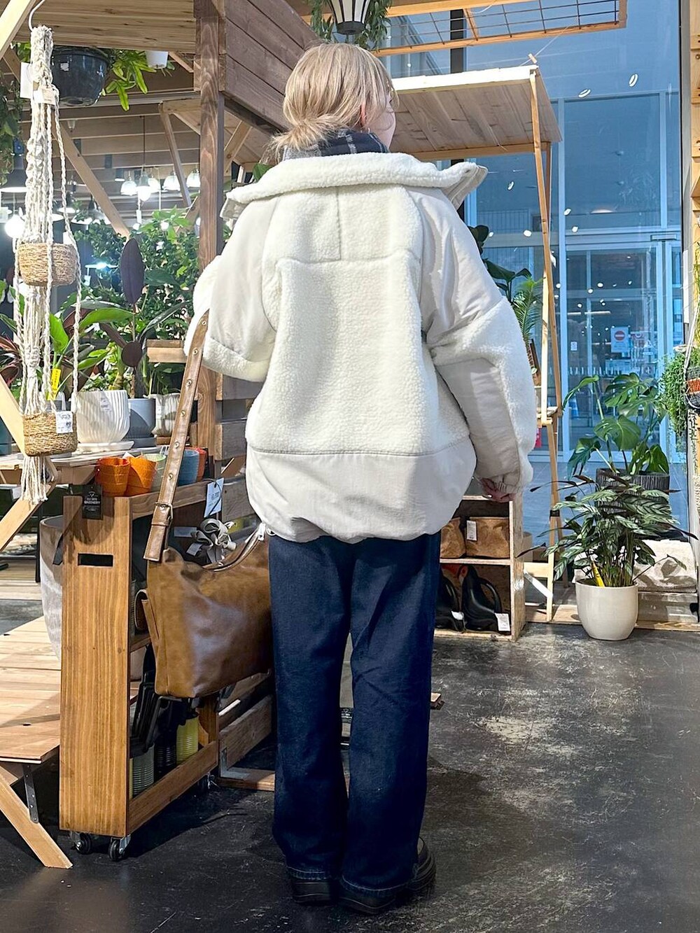 ベージュ系のブルゾン、ブルー系のデニムパンツ、ブラウン系のブーツを着用したレディースの冬コーディネートの3枚目の写真