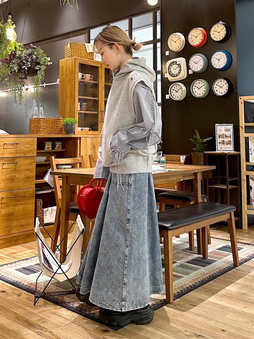 ブラック系のスニーカー、レッド系のショルダーバッグ、ブルー系のスカートを着用したレディースの冬コーディネートの4枚目の写真