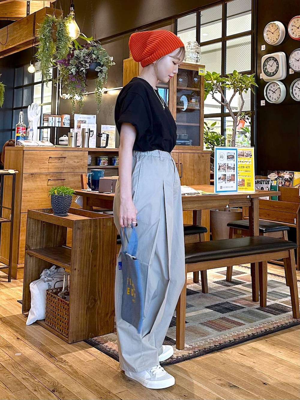 ホワイト系のスニーカー、グレー系のチノパンツ、ブルー系のトートバッグを着用したレディースの冬コーディネートの3枚目の写真