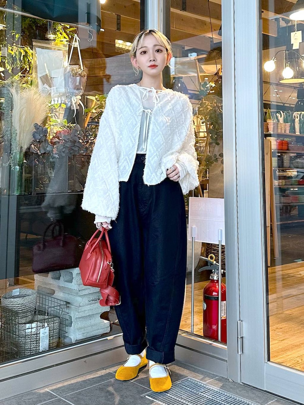 イエロー系のパンプス、ブルー系のその他パンツ、ブラウン系のショルダーバッグを着用したレディースの秋コーディネートの4枚目の写真