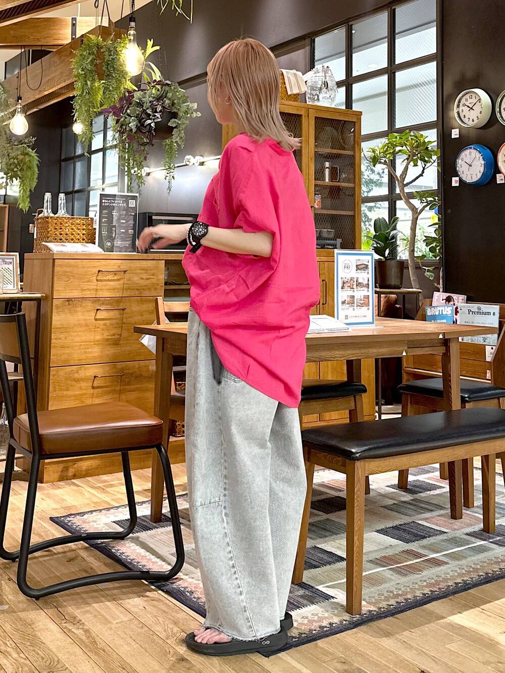 ブラック系のショルダーバッグ、グレー系のデニムパンツ、ブラック系のサンダルを着用したレディースの春コーディネートの2枚目の写真