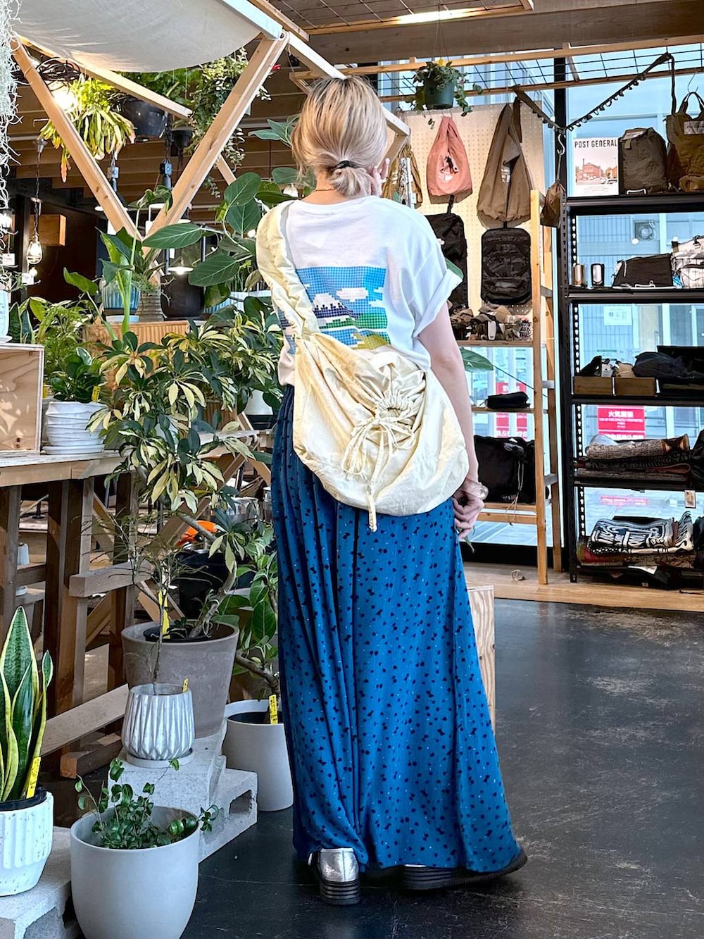 ベージュ系のショルダーバッグ、ブルー系のその他パンツ、シルバー系のスニーカーを着用したレディースの夏コーディネートの3枚目の写真