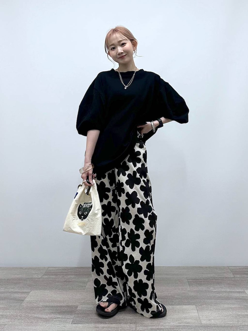 ホワイト系のショルダーバッグ、ブラック系のTシャツ/カットソー、ブラック系のサンダルを着用したレディースの春コーディネートの5枚目の写真