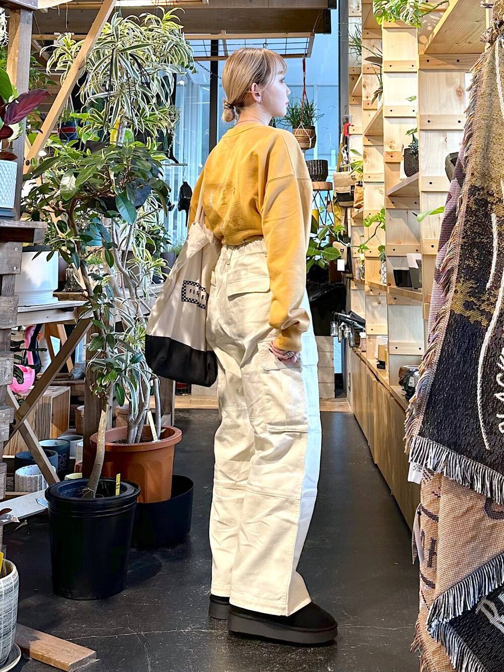 ブラック系のトートバッグ、ブラック系のブーツ、ホワイト系のその他パンツを着用したレディースの冬コーディネートの3枚目の写真